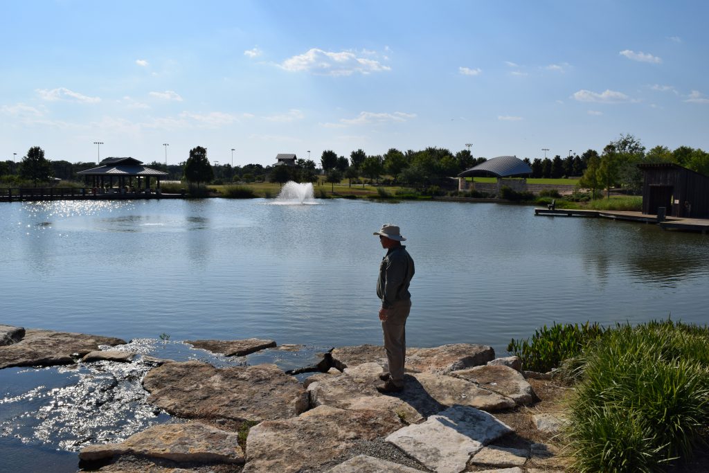 scenic lake and pond management - man gazing out at pond