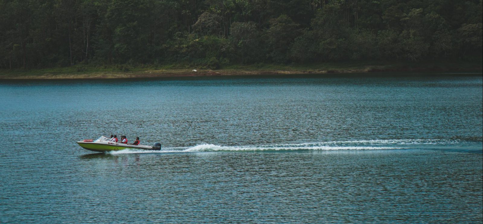 lake scenic shot with mountains - clients boating having fun on water