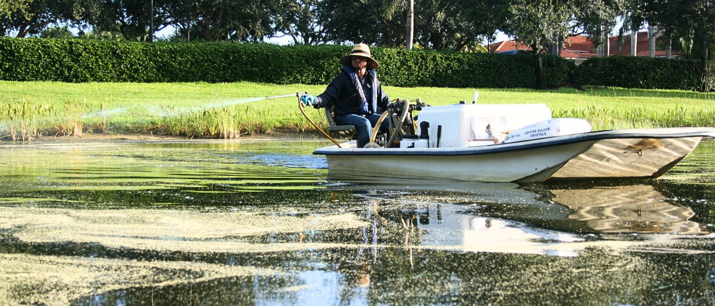 Aquatic Management expert applying algae treatment to a community lake