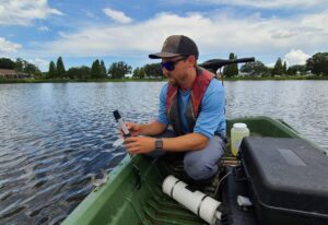 Lake Management Expert performing water quality testing in community lake