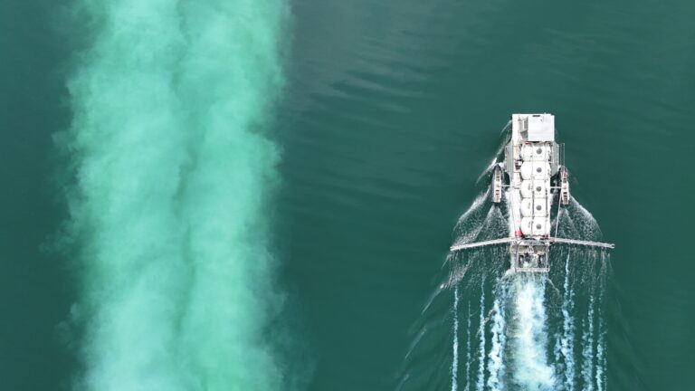 large-barge-in-water-applying-alum-white-trail-in-water