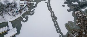 aerial image of lake homes with ice and snow covered lake and docks (1)