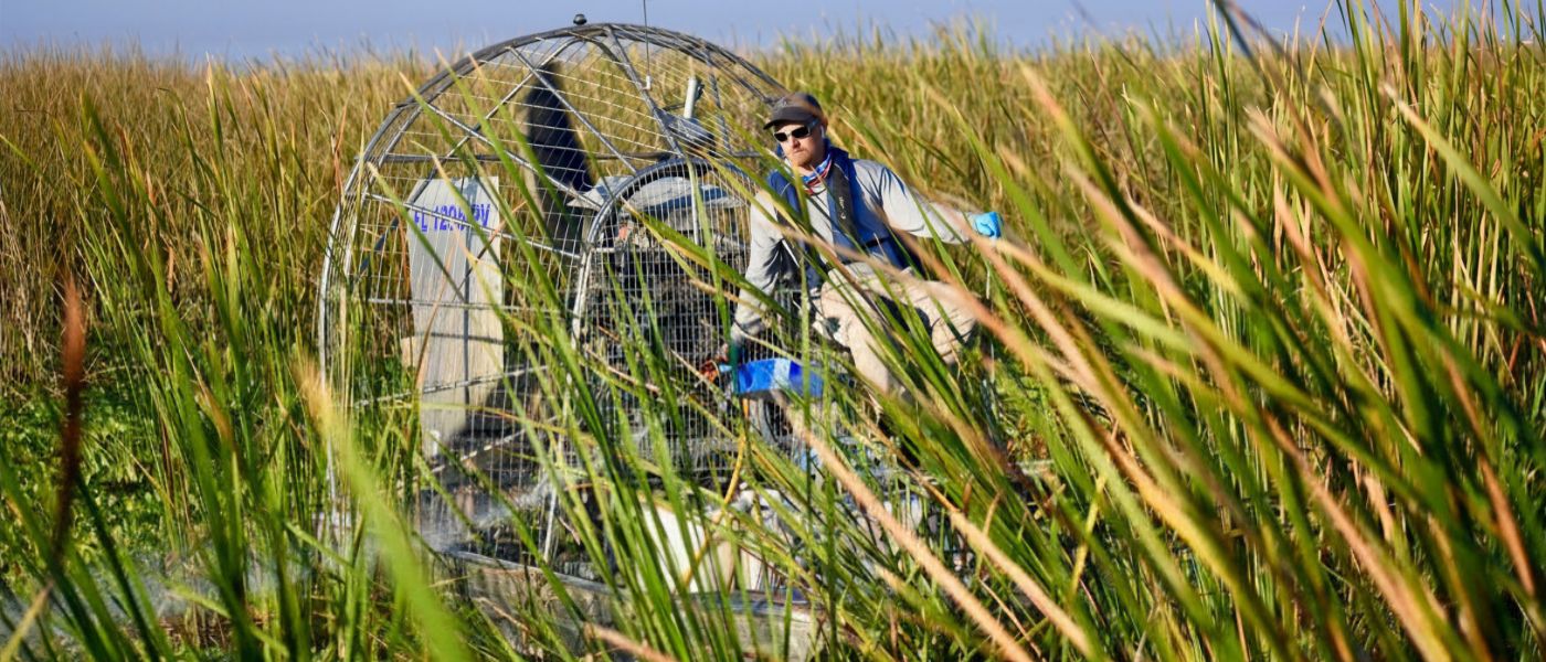 aquatic technician applying treatment to control phragmities in different environments on an airboat