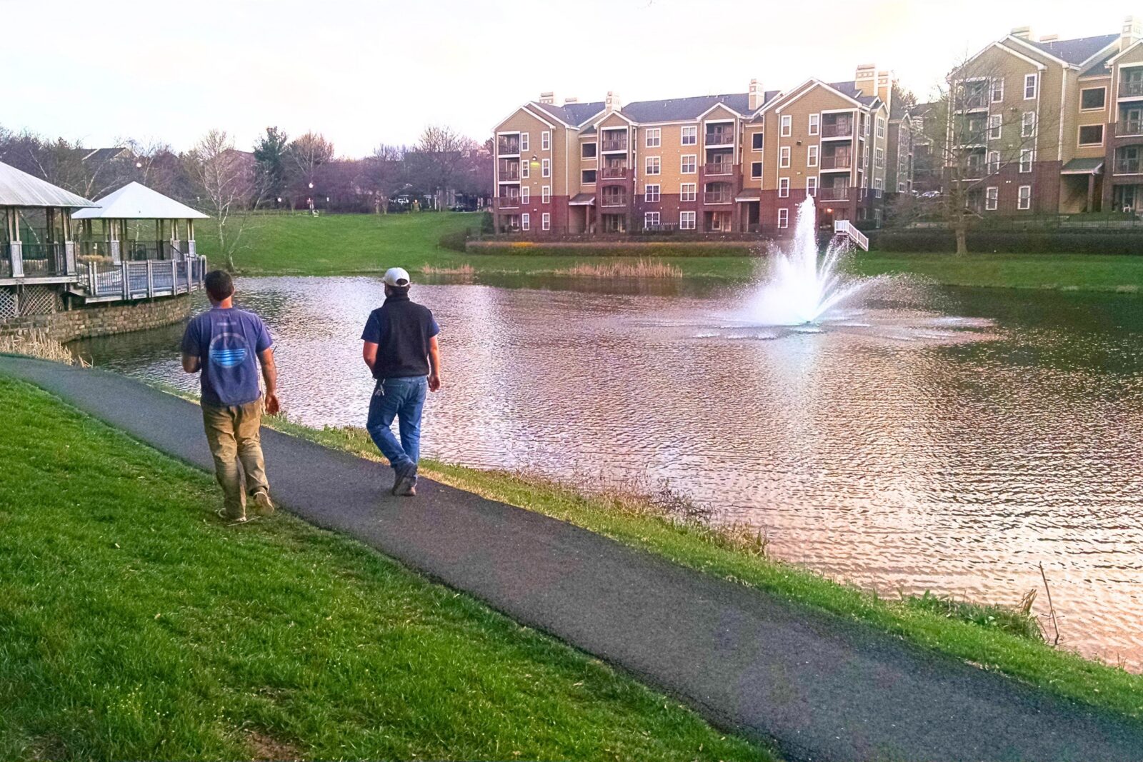 lake technicians walking around community lake with fountain