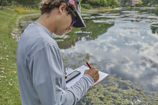 Aquatic professional performing water quality testing in a pond